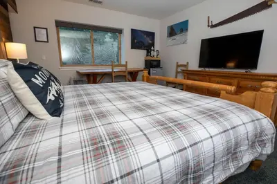 a bedroom with a bed and a flat screen tv at Ski in Ski out King Bed Suite Hotel Room Near Village in Kirkwood