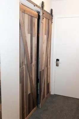 a sliding barn door in a room with a white wall at Ski in Ski out Dream Studio Village Mtn Views in Kirkwood