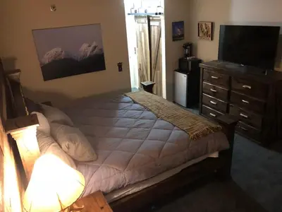 a bedroom with a bed and a dresser and a television at True Ski in out Large 2 bdrm Mtn Views 4 beds in Kirkwood