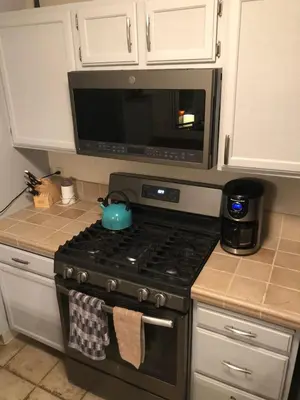 a kitchen with a stove with a microwave above it at True Ski in out Large 2 bdrm Mtn Views 4 beds in Kirkwood