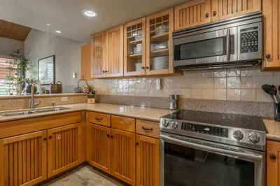 a kitchen with wooden cabinets and stainless steel appliances at Bridges 3 in Mammoth Lakes