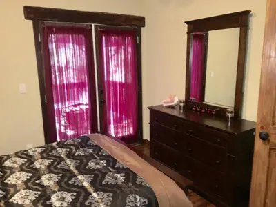 a bedroom with a bed and a dresser with a mirror at Gorgeous cottage in fair oaks village in Fair Oaks