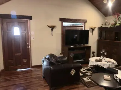 a living room with a leather chair and a television at Gorgeous cottage in fair oaks village in Fair Oaks