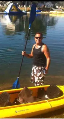 a man standing in the water with an oar in a canoe at Magnificent stay at fair oaks village in Fair Oaks