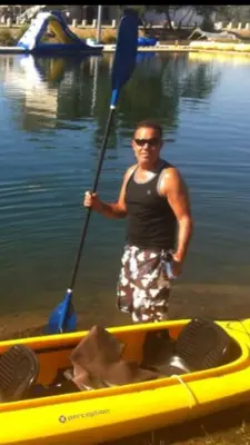 a man standing in a yellow boat with an oar at Charming vintage village house in Fair Oaks