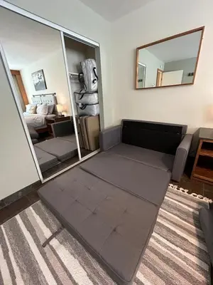 a living room with a couch and a mirror at The Meadows- Modern 1BedroomDeck and Fireplace in Kirkwood