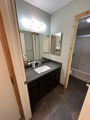 a bathroom with a sink and a large mirror at The Meadows- Modern 1BedroomDeck and Fireplace in Kirkwood