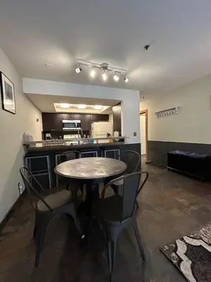 a room with a table and chairs and a kitchen at The Meadows- Modern 1BedroomDeck and Fireplace in Kirkwood