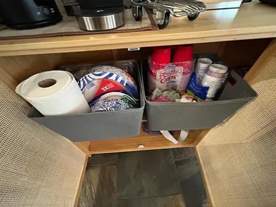 a drawer in a cabinet with toilet paper and other items at The Meadows Modern Suite Deck & Garage Parking in Kirkwood