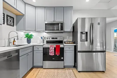 a kitchen with white cabinets and stainless steel appliances at Luxury Cabin in Budget-Hot Tub -Apple Hills-Tahoe in Pollock Pines