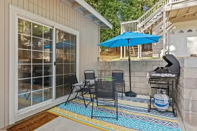 a patio with a table and a blue umbrella at Luxury Cabin in Budget-Hot Tub -Apple Hills-Tahoe in Pollock Pines