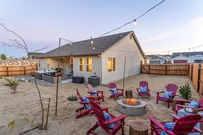 a backyard with red chairs and a fire pit at Dusty Sage Hollow in Fernley