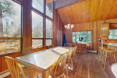 a dining room with a table and chairs and windows at Alpenglow at Dollar Point in Dollar Point