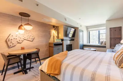 a bedroom with a large bed and a table at Mammoth Monache Resort in Mammoth Lakes