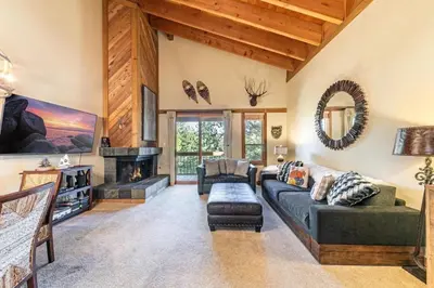 a living room with a couch and a fireplace at Family cabin on resort at Northstar in Truckee