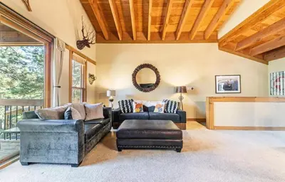 a living room with two couches and a tv at Family cabin on resort at Northstar in Truckee