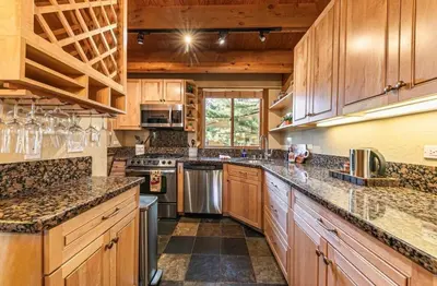 a large kitchen with wooden cabinets and granite counter tops at Family cabin on resort at Northstar in Truckee