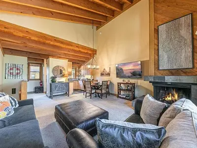 a living room with a couch and a fireplace at Family cabin on resort at Northstar in Truckee