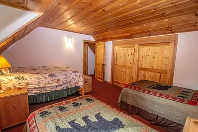 a bedroom with two beds in a room with wooden ceilings at Nightingale's Nest in Carnelian Bay