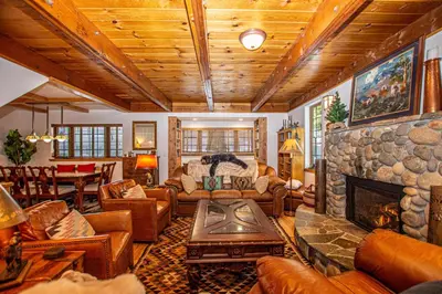 a living room with couches and a stone fireplace at Nightingale's Nest in Carnelian Bay