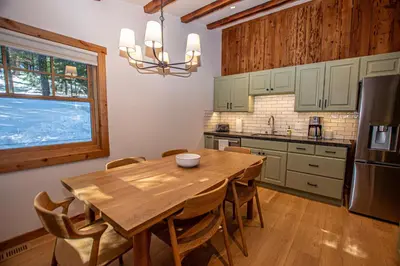 a kitchen with a wooden table and a refrigerator at Cedar Cottage in Homewood