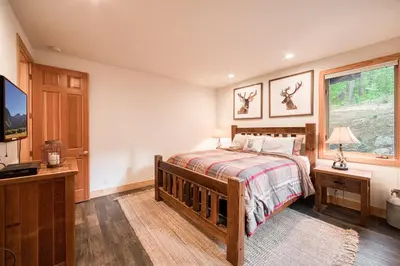 a bedroom with a bed and a tv and a window at Easy Living at Northstar by Tahoe Getaways - 4BR Pet Friendly w/ Ski Shuttle & HOA in Truckee