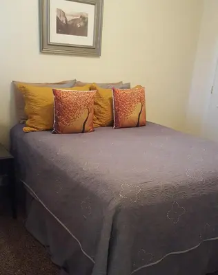 a bed with a bunch of pillows on it at Nature's Inn Bed and Breakfast in Ahwahnee