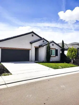 a white house with a garage on a street at Vip Class Two in Lodi