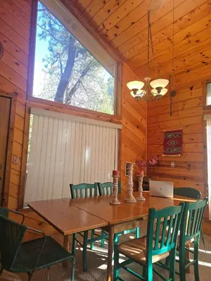 a dining room with a wooden table and chairs at The Cozy Knotty Pine Enchantment Retreat in Long Barn