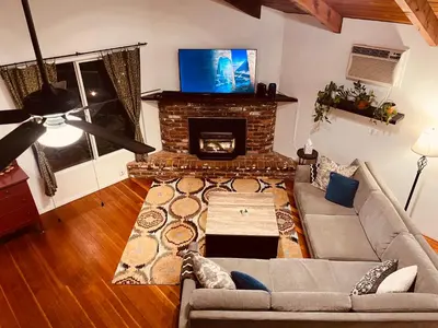 a living room with a couch and a fireplace at Cozy Riverfront Home with EV charger in Three Rivers