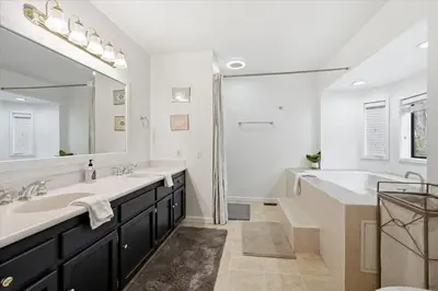 a bathroom with two sinks and a tub and a large mirror at Fun Getaway with Golf HotTub Volleyball and more in Oakhurst