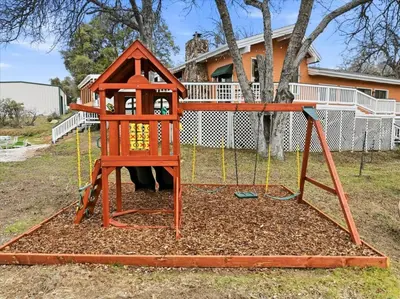 a playground in front of a house at Fun Getaway with Golf HotTub Volleyball and more in Oakhurst