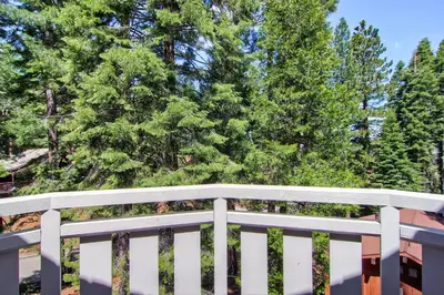 a white fence with trees in the background at Ahwahnichi Lodge in Yosemite West