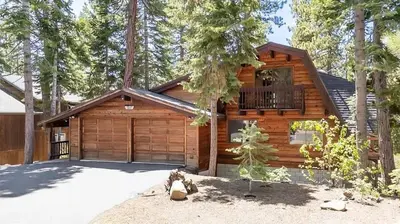 a log cabin with a garage and a balcony at Three Bears Getaway Tahoe in Kings Beach