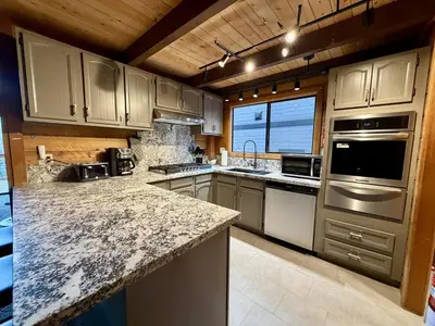 a kitchen with marble counter tops and a large window at Three Bears Getaway Tahoe in Kings Beach