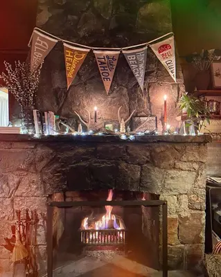 a stone fireplace with candles and flags above it at Campo Carnelian in Carnelian Bay