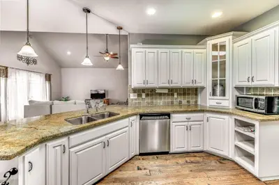 a kitchen with white cabinets and a sink at Quiet Murphys getaway steps away from 25+ wineries in Murphys