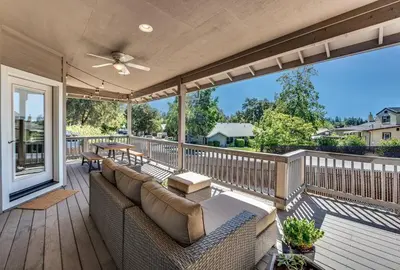 a porch with a couch on a wooden deck at Quiet Murphys getaway steps away from 25+ wineries in Murphys