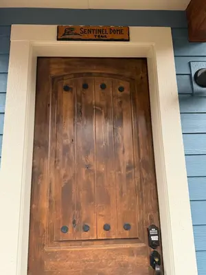 a front door of a house with a sign above it at Yosemite's Inn the Woods in Ahwahnee