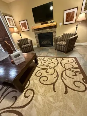 a living room with a fireplace and a television at Yosemite's Inn the Woods in Ahwahnee
