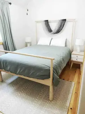 a bed with a wooden frame in a bedroom at Stay at Whispering Pines, only 25 mi to Yosemite! in Midpines