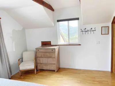 a bedroom with a dresser and a chair and a window at Cozy Woodworker's Cabin, 26 miles to Yosemite! in Midpines