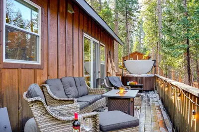 a deck with wicker chairs and a tub on a house at Game Room and Hot Tub! Dog-Friendly Arnold Retreat in Arnold