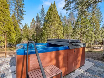 a jacuzzi tub sitting on top of a wooden deck at Forest Retreat that accommodates 29 people near Yosemite & Bass Lake in Oakhurst
