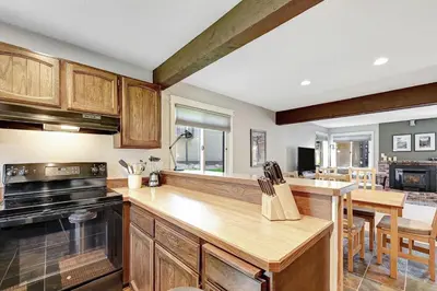 a kitchen with wooden cabinets and a counter top at Mountain Condo | Spa Pool and Ski Shuttle Access in Mammoth Lakes