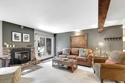a living room with a couch and a fireplace at Mountain Condo | Spa Pool and Ski Shuttle Access in Mammoth Lakes