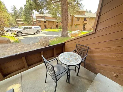 a patio with a table and chairs on a balcony at Mountain Condo | Spa Pool and Ski Shuttle Access in Mammoth Lakes
