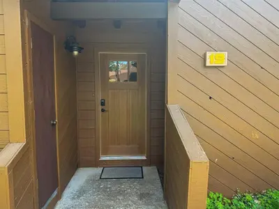 a front door of a house with a wooden door at Mountain Condo | Spa Pool and Ski Shuttle Access in Mammoth Lakes