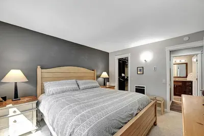 a bedroom with a large bed with a gray wall at Mountain Condo | Spa Pool and Ski Shuttle Access in Mammoth Lakes