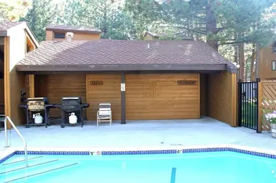 a garage with a grill and a swimming pool at Mountain Condo | Spa Pool and Ski Shuttle Access in Mammoth Lakes